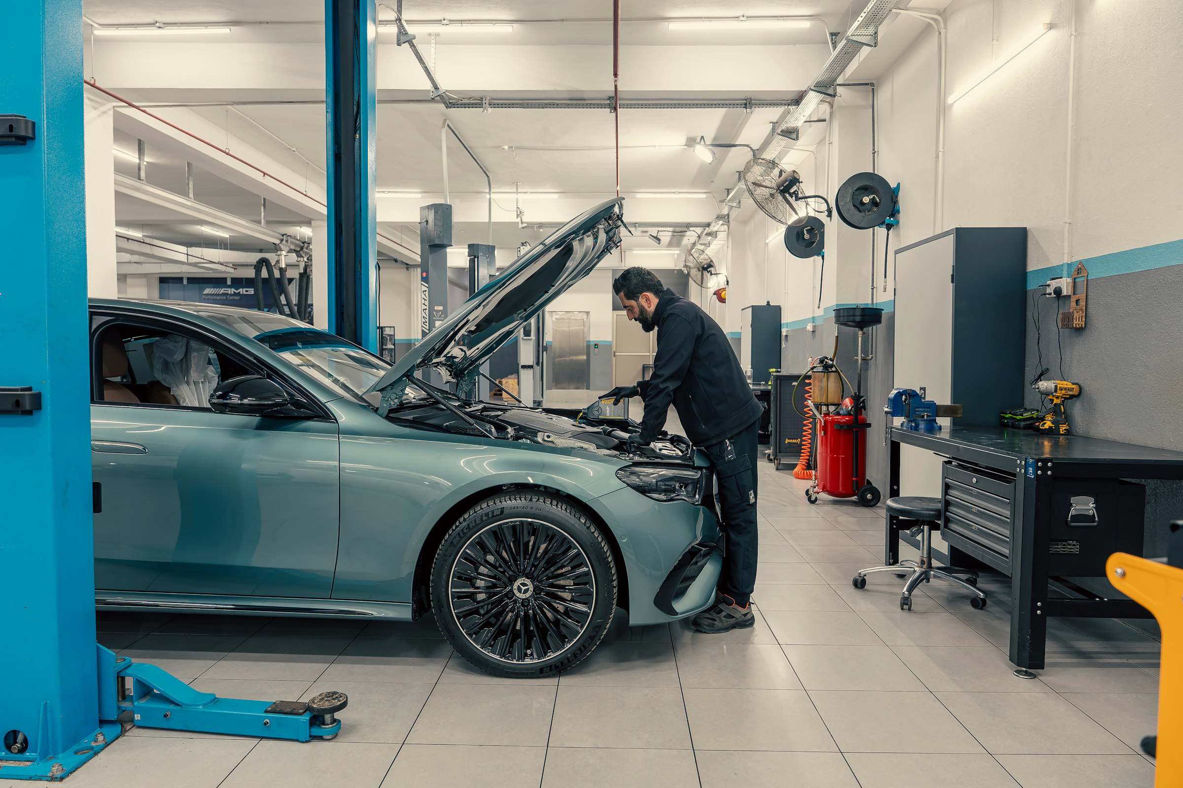 Mechaniker arbeitet im Motorraum eines Mercedes in der Werkstatt