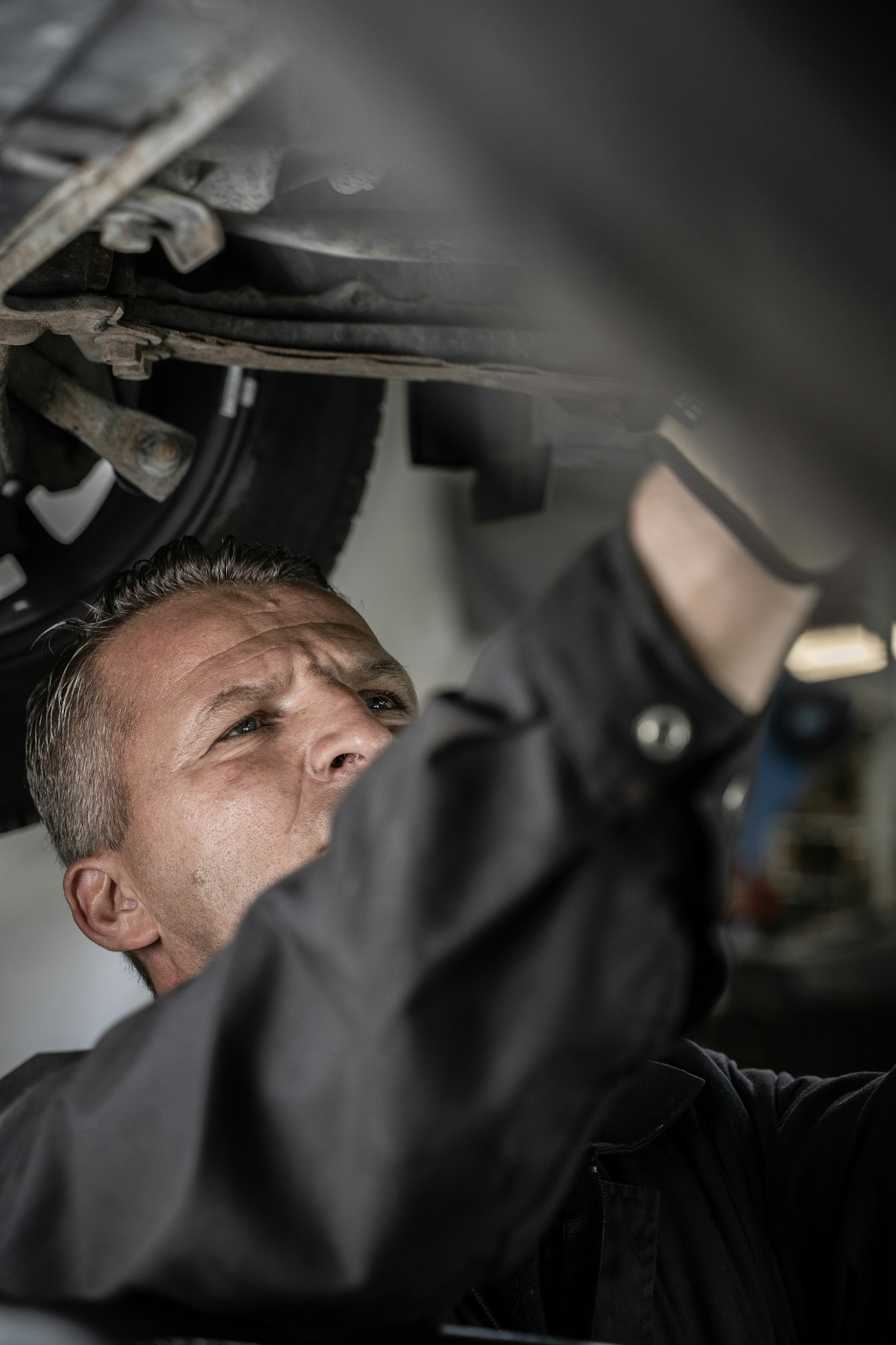Mechaniker arbeitet am Unterboden eines Fahrzeugs